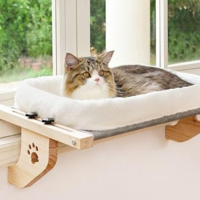 A cat lounging on a Window Cat Hammock by the window, enjoying the sun and view from its cozy spot.